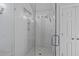 Modern glass-enclosed shower featuring white tile, accent strips, and convenient door at 5220 Linksland Dr, Holly Springs, NC 27540