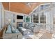 Bright sunroom with vaulted wood ceilings, fireplace, and comfortable wicker seating at 5220 Linksland Dr, Holly Springs, NC 27540