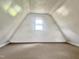 Attic space offering ample room for storage, illuminated by a centered window at 540 S Cheatham St, Franklinton, NC 27525
