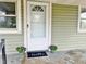 Charming front porch with potted plants and a 'hello' welcome mat by a bright white front door at 540 S Cheatham St, Franklinton, NC 27525