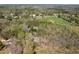 Expansive aerial view of the property showcasing its wooded landscape and proximity to open fields and a nearby lake at 55 J B Rd, Louisburg, NC 27549
