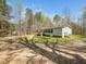 A quaint home with a charming porch nestled within a serene landscape and mature trees at 55 J B Rd, Louisburg, NC 27549