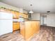 Bright kitchen featuring wood cabinets, an island, modern appliances, and wood-look floors at 55 J B Rd, Louisburg, NC 27549
