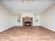 Cozy living room featuring a brick fireplace, wood-look floors, and plenty of natural light at 55 J B Rd, Louisburg, NC 27549