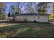 View of a house featuring a cozy wooden deck in the backyard, set against a backdrop of trees at 5917 Meadowlark Ln, Raleigh, NC 27610