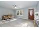 Sun-filled living room featuring a ceiling fan, gray walls, and front door with decorative oval window at 5917 Meadowlark Ln, Raleigh, NC 27610