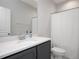 Bathroom with a gray vanity, white countertop, a simple mirror, and a white shower curtain at 5918 Giddings St, Raleigh, NC 27616