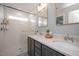 Modern bathroom with dual sinks, quartz countertops, and a tiled walk-in shower with a glass door at 5918 Giddings St, Raleigh, NC 27616