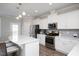Well-lit kitchen featuring stainless steel appliances, white cabinets, and a breakfast bar at 5918 Giddings St, Raleigh, NC 27616