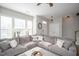 Bright living room featuring a large gray sectional sofa and multiple windows providing natural light at 5918 Giddings St, Raleigh, NC 27616