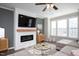 Bright living room with fireplace, mounted TV, ceiling fan, and lots of natural light at 5918 Giddings St, Raleigh, NC 27616