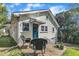 Charming backyard with a deck, black wicker chairs, and a yellow house with a blue door at 602 Dunbar St, Durham, NC 27701