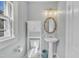 Charming half-bathroom featuring a pedestal sink, storage cabinet, and stylish mirror at 602 Dunbar St, Durham, NC 27701