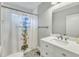 Bathroom with black-and-white patterned floor tiles, a vanity with white cabinet, and a shower with colorful shower curtain at 602 Dunbar St, Durham, NC 27701