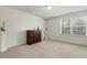 A carpeted bedroom featuring a window, wooden cabinet, and white walls at 6021 Watsonia Dr, Zebulon, NC 27597