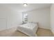 A bright bedroom featuring carpet, a queen bed with white bedding, and a sunny window at 6021 Watsonia Dr, Zebulon, NC 27597