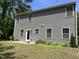 Rear exterior of a two-story home featuring a door, windows, and landscaping at 6021 Watsonia Dr, Zebulon, NC 27597