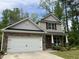 Charming two-story home featuring stone accents, a two-car garage, and a well-manicured front yard at 6021 Watsonia Dr, Zebulon, NC 27597