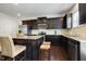A modern kitchen with stainless appliances, granite countertops, a breakfast bar, and dark wood cabinets at 6021 Watsonia Dr, Zebulon, NC 27597