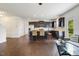 An open-concept kitchen with an island, hardwood floors, dark cabinetry, and stainless steel appliances at 6021 Watsonia Dr, Zebulon, NC 27597