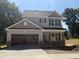 New two-story home with gray siding, dark shutters, brick accents, and a two-car garage at 61 Fetterbush Way, Clayton, NC 27520