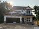 New construction home featuring a two-car garage and large windows, wrapped for weather protection during the building process at 61 Fetterbush Way, Clayton, NC 27520