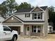 Charming two-story home featuring a mix of siding and brick accents with black shutters at 61 Fetterbush Way, Clayton, NC 27520