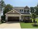 Two-story home with neutral siding, dark shutters, and a two-car garage in a suburban setting at 61 Fetterbush Way, Clayton, NC 27520