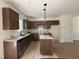 Bright kitchen featuring wood floors, granite counters, brown cabinets, and stainless steel appliances at 61 Fetterbush Way, Clayton, NC 27520