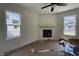 Living room featuring light colored walls, a fireplace, two windows, and a ceiling fan at 61 Fetterbush Way, Clayton, NC 27520