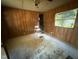 Bedroom with wood paneling, stained concrete floors, a lone chair, and a window overlooking trees at 640 Crocker Rd, Smithfield, NC 27577