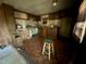Dilapidated kitchen featuring wood cabinets and paneling with a wooden stool in the center of the room at 640 Crocker Rd, Smithfield, NC 27577