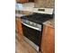 New stainless gas stove with granite countertops and dark wood cabinets at 640 Crocker Rd, Smithfield, NC 27577