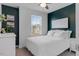 A cozy bedroom with white bedding, a ceiling fan, and two-tone paint at 6412 Nurture Ave, Raleigh, NC 27616