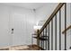 Inviting entryway with a white door, stylish light fixture, and modern staircase with metal railings at 6412 Nurture Ave, Raleigh, NC 27616