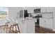 Bright and modern kitchen with white cabinetry, stainless steel appliances, and a center island with seating at 6412 Nurture Ave, Raleigh, NC 27616