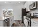 Modern kitchen with stainless steel appliances, light countertops, white subway tile backsplash, and wood-look flooring at 6412 Nurture Ave, Raleigh, NC 27616