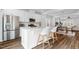 Modern kitchen with a center island, bar stool seating, and open floor plan to the dining and living areas at 6412 Nurture Ave, Raleigh, NC 27616