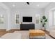 Bright living room featuring modern furnishings, a ceiling fan, and large windows at 6412 Nurture Ave, Raleigh, NC 27616