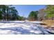 A snow-covered expanse, this parcel of land features a mix of evergreen trees and open space under a bright sky at 6509A Fowler Rd, Zebulon, NC 27597