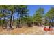View of land and wooded area in winter with light dusting of snow and red tractor implement at 6509A Fowler Rd, Zebulon, NC 27597