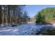 View of the land and wooded area with snow covered ground at 6509A Fowler Rd, Zebulon, NC 27597