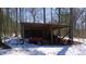 View of an outbuilding structure with tractor inside on the snow-covered ground at 6509A Fowler Rd, Zebulon, NC 27597
