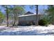 Rear exterior of the home in winter with snow covered ground surrounded by trees at 6509A Fowler Rd, Zebulon, NC 27597