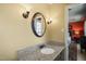 Bathroom featuring a granite countertop vanity, oval mirror, and sconce lighting at 7109 River Birch Dr, Raleigh, NC 27613