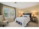 Bright bedroom features a queen bed, neutral walls, and a window view at 7109 River Birch Dr, Raleigh, NC 27613