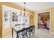 Cozy dining area with glass table, chandelier, big windows, and view to the living room at 7109 River Birch Dr, Raleigh, NC 27613