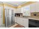 Clean kitchen with white cabinets, granite countertops, stainless steel appliances, and tiled backsplash at 7109 River Birch Dr, Raleigh, NC 27613