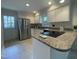 An inviting kitchen with stainless steel appliances, granite countertops, white cabinets, and backyard access at 7109 River Birch Dr, Raleigh, NC 27613