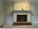 Cozy living room with a traditional fireplace featuring a white mantel and a brick hearth at 7109 River Birch Dr, Raleigh, NC 27613